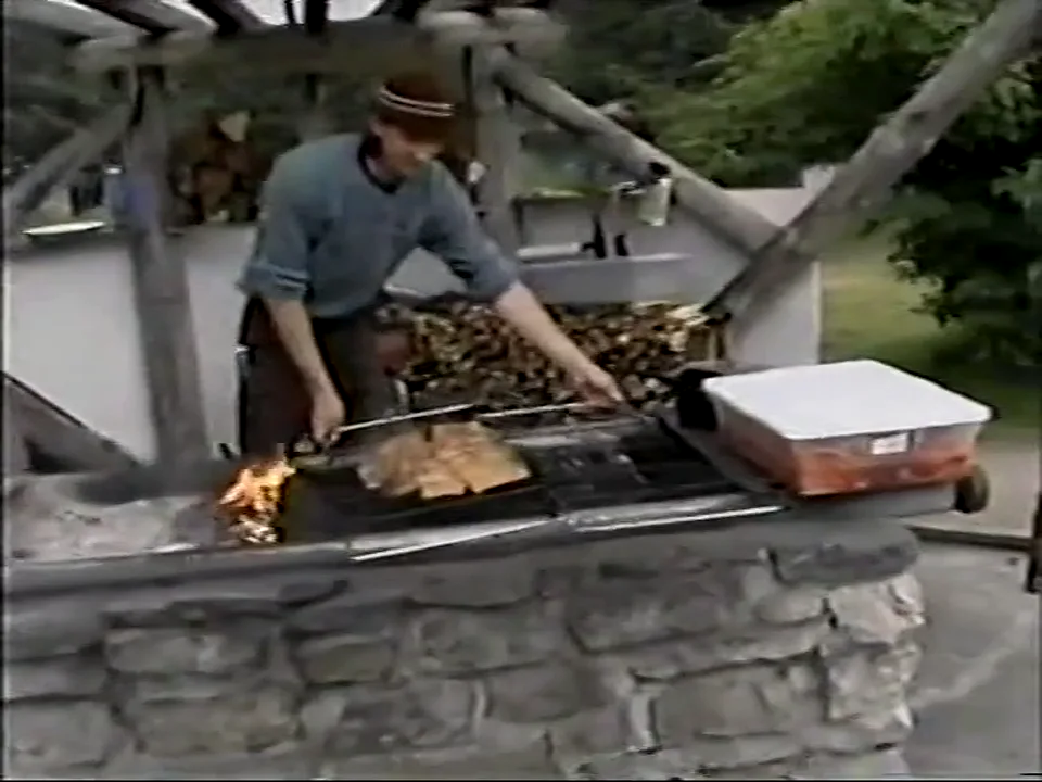 Salmon cooking on the outdoor stone grill at Taku Lodge, 1998