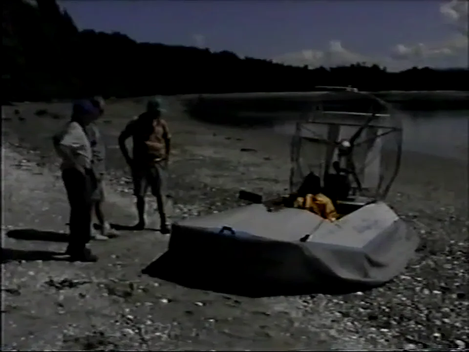 Dave Crawford's Vanguard hovercraft pulled up on the beach at Sandy Island, with the crew standing beside it, 1998