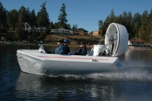 Ducted AM-14 hovercraft running on the water with two people aboard
