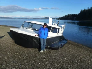Angela Phillips standing beside an Explorer 24 on a gravel beach