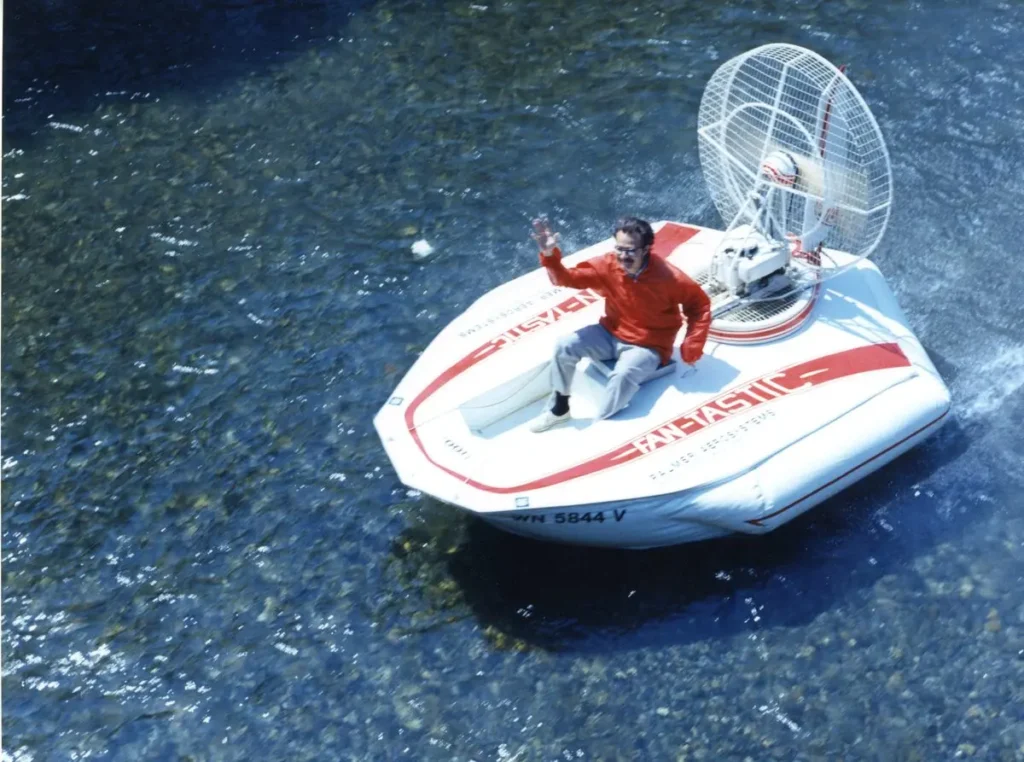 Barry Palmer driving the white Fantastic 1 hovercraft prototype on the water, 1975