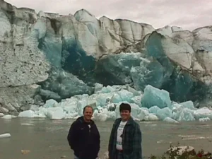 Two of the crew standing in front of the Taku Glacier ice face, 1998