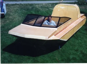 The Explorer 20 prototype under construction with its windshield fitted and a builder at the helm, 1995