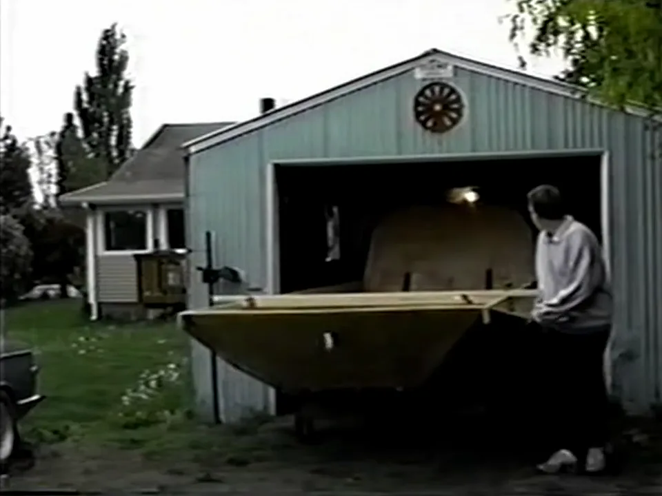 The bare Explorer 20 prototype hull being rolled out of the small rented garage where it was built, 1995