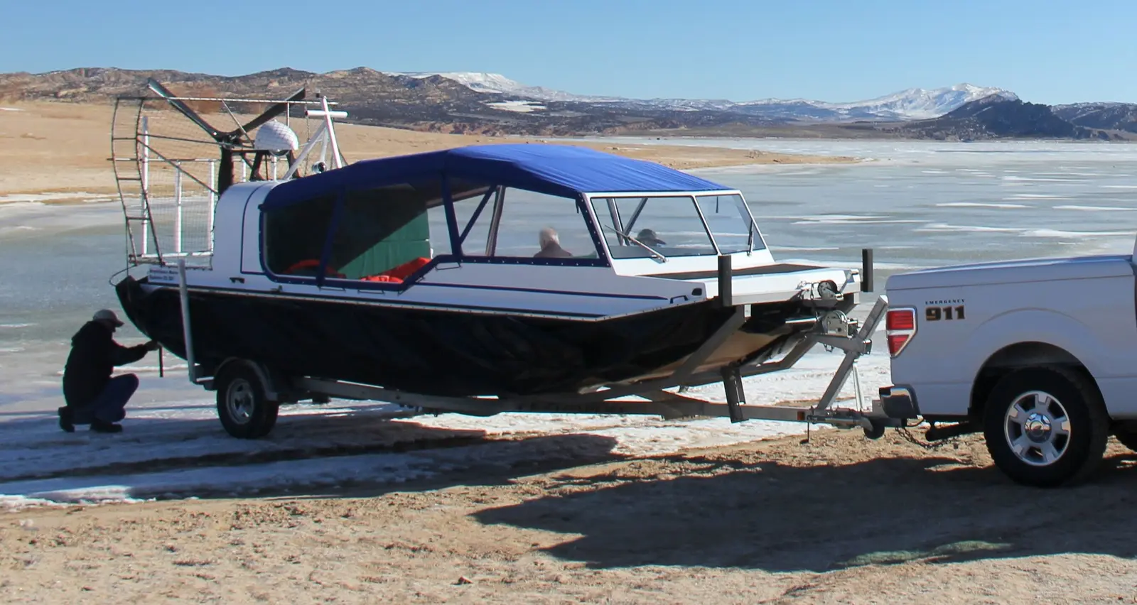 Explorer 22 on its trailer behind a pickup on a frozen lake shore