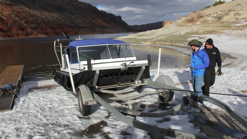 Daggett County SAR Explorer 22 TDi sitting on its ground deployment trailer at an icy ramp, with crew beside it