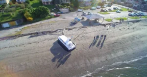 Aerial of an Explorer 24 on a beach with people walking