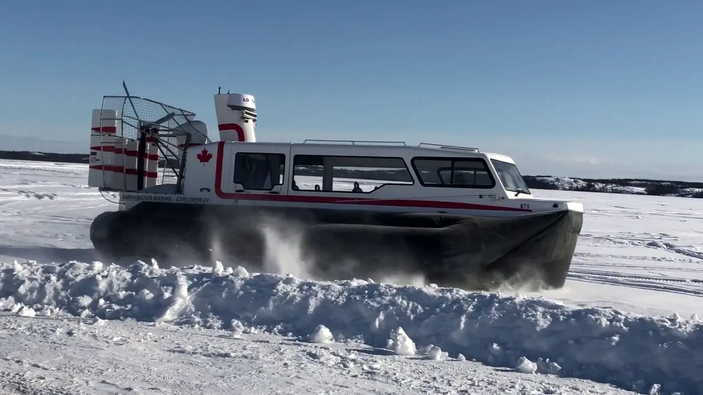 Explorer 24 with Canadian flags running through snow