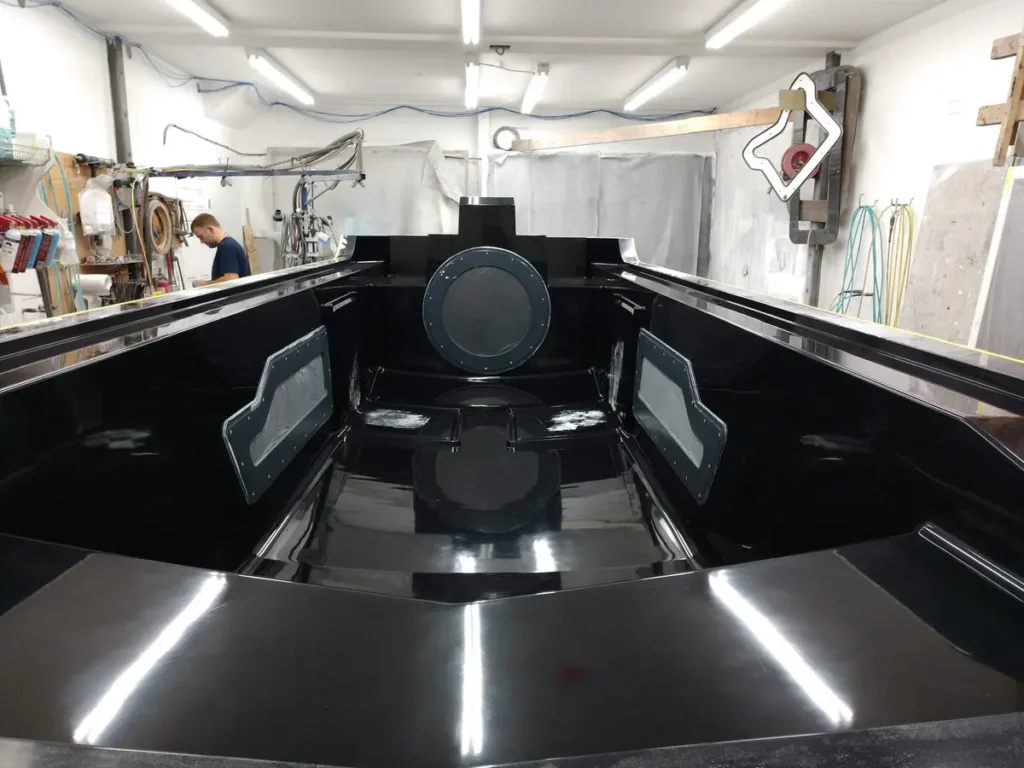 The Explorer 24 deck mold being loaded with fiber and core in the shop
