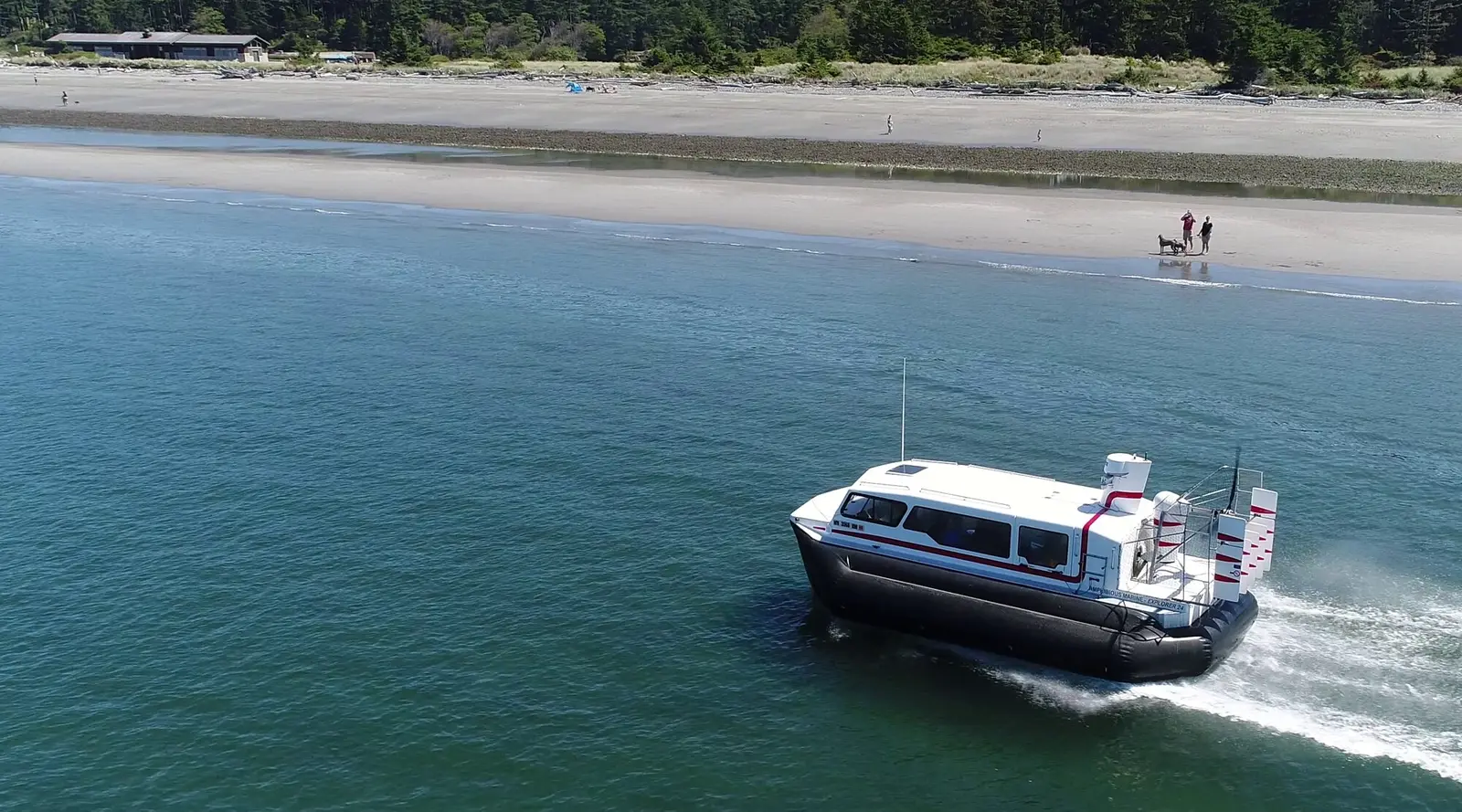 Explorer 24 hovercraft running along West Beach at Deception Pass State Park, throwing spray