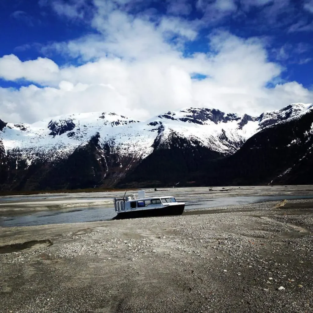 An Explorer 24 hovercraft on a gravel flat below snow covered mountains near Juneau