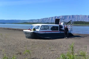 Paul's Explorer 24 on a sandy beach below a long ridge on the Mackenzie River