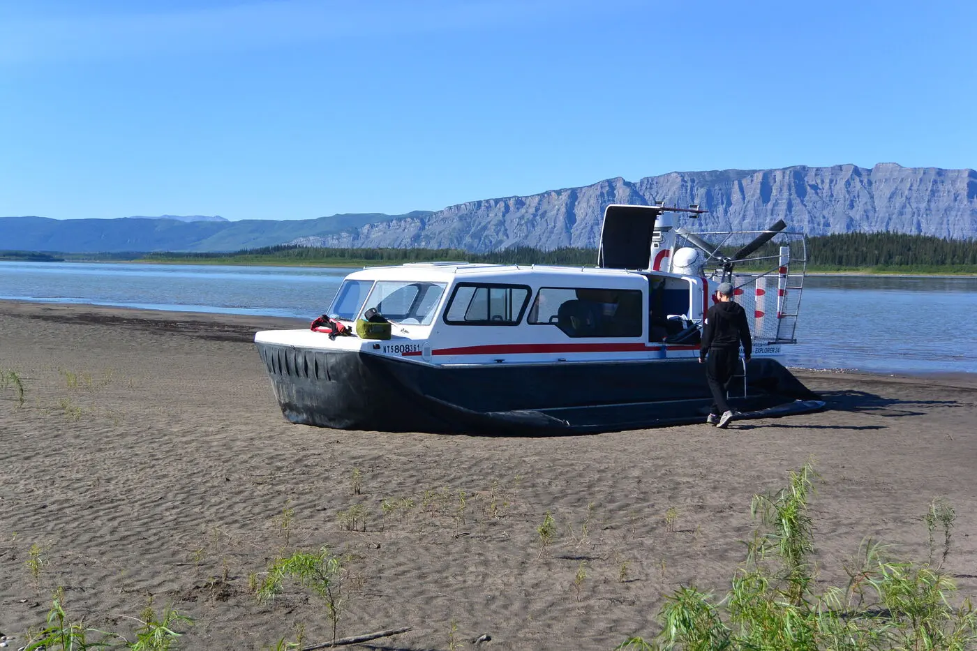 Paul's Explorer 24 on a sandy beach below a long ridge on the Mackenzie River