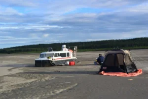 Explorer 24 on a Mackenzie River sand bar beside a camping tent