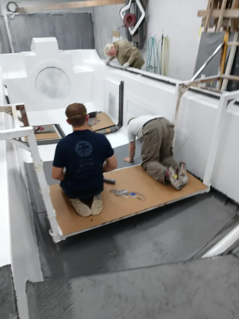 Builders placing core material inside an Explorer 24 part in the shop