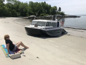 Explorer 24 on a beach in Portland, Maine with a sunbather nearby