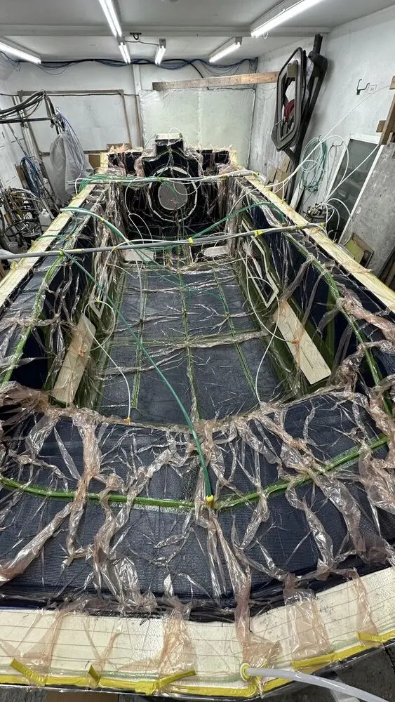 Explorer 24 deck under a vacuum infusion bag in the Amphibious Marine shop