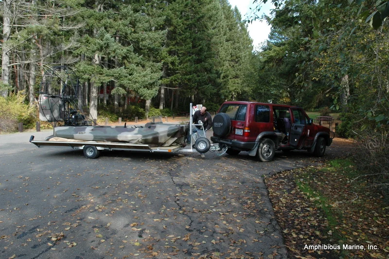 Hovercraft on a fly on/off trailer at a lake, trailer sides tilted down