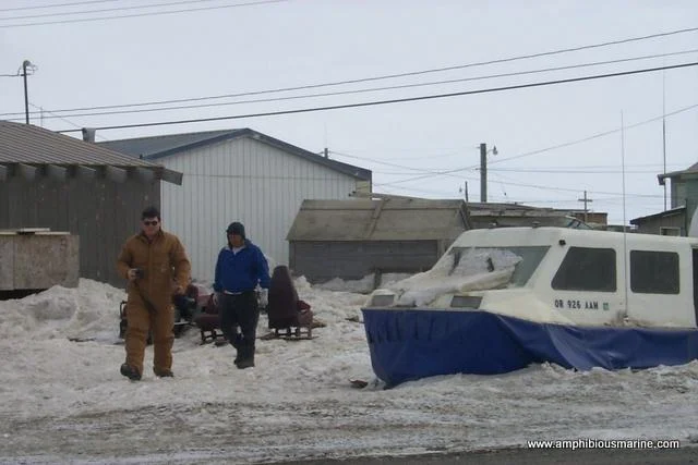 A consulting visit in Barrow, Alaska: a hovercraft in the snow beside village buildings