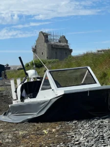 Mark's Explorer 22 parked on the grass below a ruined castle tower
