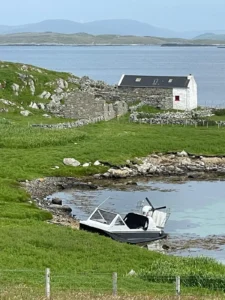 Mark's Explorer 22 at the water's edge below a croft house and stone wall