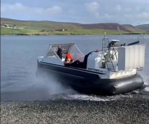 Mark's Explorer 22 running off a shingle beach in Shetland, throwing spray