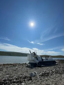Mark's Explorer 22 on a rocky shore with the sun high overhead