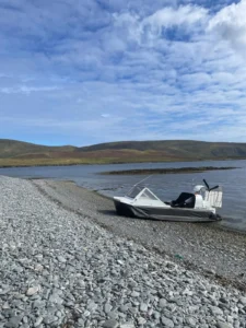 Mark's Explorer 22 on a shingle bank beside a Shetland voe