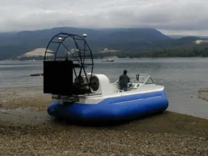Al's hovercraft with a blue skirt parked on a gravel beach