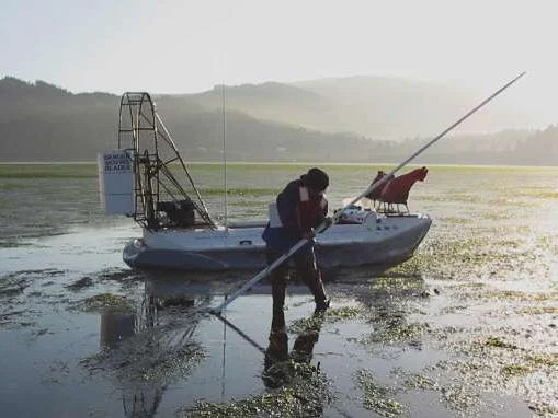 Oregon DEQ crew sampling on a tide flat from their hovercraft