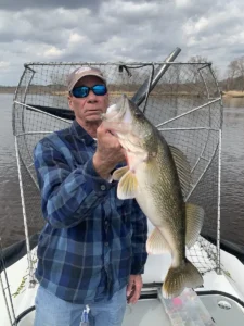 Angler holding a large fish beside a Surveyor 16