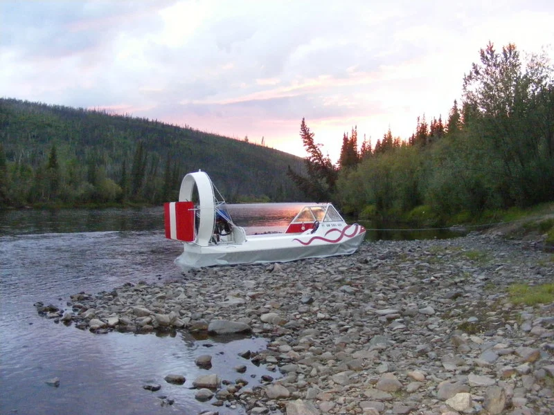Vanguard hovercraft on a gravel river bar at dusk