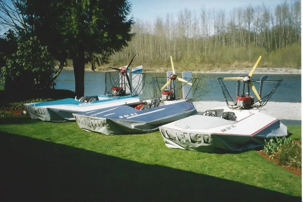 Three Vanguard prototypes parked on a lawn beside a river